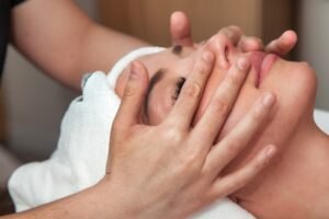 Close up face massage woman in SPA salon. Massaging therapist makes facial therapy mass for female